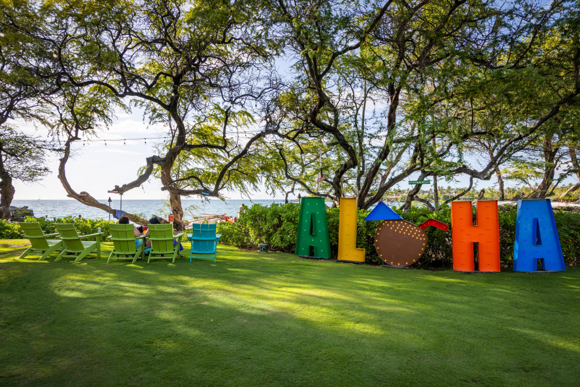 Colorful ALOHA sign on the lawn by the ocean