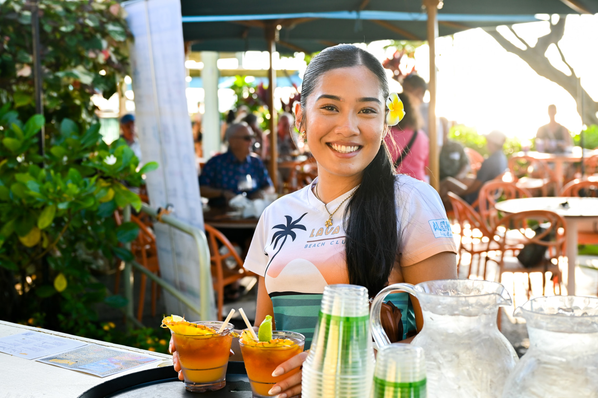Smiling Lava Lava Beach Club server holding two mai tais